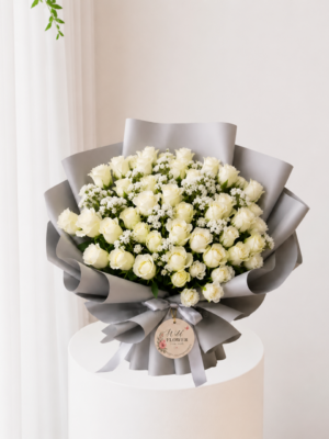 Ivory rose bouquet with fresh white roses and elegant silver wrapping Ivory rose bouquet with fresh white roses and elegant silver wrapping
