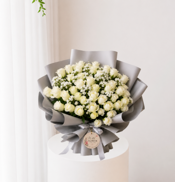 Ivory rose bouquet with fresh white roses and elegant silver wrapping Ivory rose bouquet with fresh white roses and elegant silver wrapping